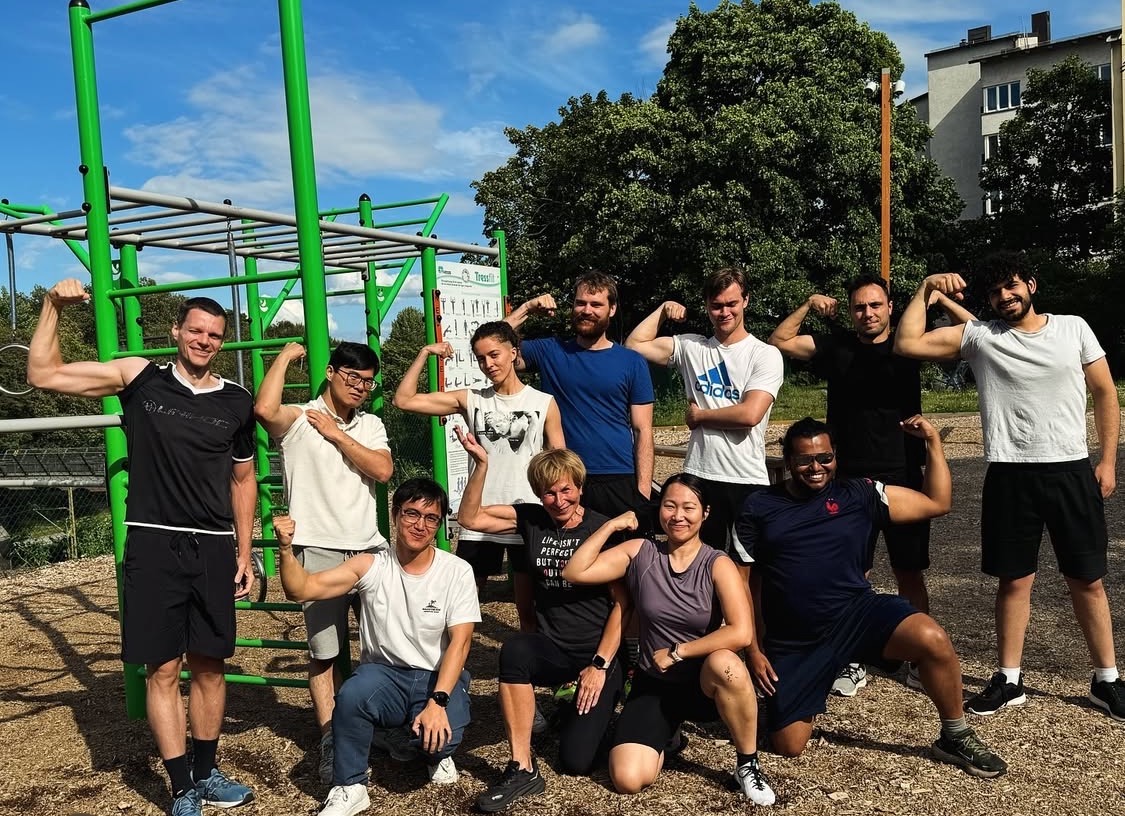 Friends posing beside outdoor exercise bars